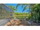 Chairs encircle a fire pit near the screened-in lanai with a tranquil pond view in the backyard at 7407 Green St, Bradenton, FL 34201