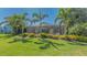 Well-maintained backyard featuring a screened-in lanai surrounded by lush landscaping and palm trees at 7407 Green St, Bradenton, FL 34201