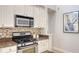 Modern kitchen features stainless steel range, granite countertops and tile backsplash at 7407 Green St, Bradenton, FL 34201