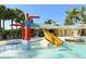 Community pool area with a fun water slide feature, palm trees, and shaded seating at 7407 Green St, Bradenton, FL 34201
