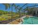 This screened in lanai offers a pool surrounded by rock features and lush tropical landscaping at 7407 Green St, Bradenton, FL 34201