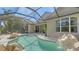 A refreshing backyard pool featuring a screen enclosure and rock waterfall feature at 7407 Green St, Bradenton, FL 34201