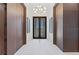 Bright foyer featuring marble floors, striking light fixture, and paneled walls leading to double doors with waterfront view at 800 Blue Shell Loop, Sarasota, FL 34240