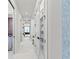 Hallway with walk-in closets featuring glass doors and marble floors, leading to additional rooms at 800 Blue Shell Loop, Sarasota, FL 34240