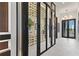 Bright hallway featuring a glass-enclosed wine cellar, marble floors, designer lighting, and modern architectural details at 800 Blue Shell Loop, Sarasota, FL 34240