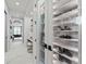 Hallway with glass-enclosed shoe closet, desk, and chair, leading to additional rooms with marble floors at 800 Blue Shell Loop, Sarasota, FL 34240