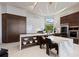 Bright, modern kitchen with waterfall island, marble countertops, stainless appliances, and decorative pendant lighting at 800 Blue Shell Loop, Sarasota, FL 34240