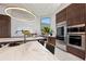 Open kitchen featuring a waterfall island with marble countertops and backsplash, stainless appliances, and wooden cabinets at 800 Blue Shell Loop, Sarasota, FL 34240