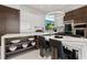 Modern kitchen with marble counters, center island, integrated dining area, and custom lighting at 800 Blue Shell Loop, Sarasota, FL 34240