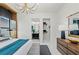 Bright main bedroom featuring modern chandelier, ensuite bathroom, and spacious walk-in closet for ultimate relaxation at 800 Blue Shell Loop, Sarasota, FL 34240