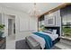 Beautifully designed main bedroom with a modern chandelier, plush bedding, and views of the outdoors at 800 Blue Shell Loop, Sarasota, FL 34240