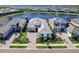 Stunning aerial view of a modern home with a tile roof and paver driveway, surrounded by lush landscaping and a serene lake at 8335 Sea Glass Ct, Sarasota, FL 34240