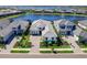 Beautiful aerial view of a modern home with a tile roof, paver driveway, lush landscaping, and a serene lake at 8335 Sea Glass Ct, Sarasota, FL 34240