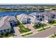 Charming aerial view of modern homes with paver driveways and tile roofs, surrounded by lush landscaping and a serene lake at 8335 Sea Glass Ct, Sarasota, FL 34240