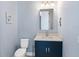 A charming powder blue bathroom with a navy vanity, chrome hardware, and nautical decor adding a touch of coastal elegance at 8335 Sea Glass Ct, Sarasota, FL 34240