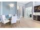 Dining area with stylish lighting fixture, a glass table, and a view to the hallway and bar at 8335 Sea Glass Ct, Sarasota, FL 34240