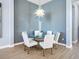 Dining area featuring statement lighting, wood accent wall, and modern table with seating for six at 8335 Sea Glass Ct, Sarasota, FL 34240