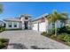 Charming single-Gathering home boasts a paver driveway, two-car garage, lush landscaping, and modern architectural details at 8335 Sea Glass Ct, Sarasota, FL 34240
