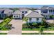 An elevated shot features a luxurious home with manicured landscaping and a brick paver driveway at 8335 Sea Glass Ct, Sarasota, FL 34240