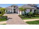 A sunny view showcases the home's entrance, driveway, and lush landscaping at 8335 Sea Glass Ct, Sarasota, FL 34240