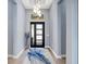 Bright foyer featuring stylish light fixture, modern front door, and neutral walls at 8335 Sea Glass Ct, Sarasota, FL 34240