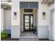 A close-up of the house's modern front door with sidelights and stylish sconces at 8335 Sea Glass Ct, Sarasota, FL 34240