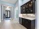 Hallway featuring dark wood bar cabinets with glass doors, wine storage, and designer tile backsplash at 8335 Sea Glass Ct, Sarasota, FL 34240