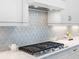Close-up on kitchen backsplash, stainless steel stove, and white cabinetry at 8335 Sea Glass Ct, Sarasota, FL 34240