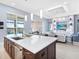 Open concept kitchen with large island flowing into living area with built-in shelving at 8335 Sea Glass Ct, Sarasota, FL 34240
