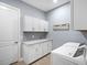 Well-lit laundry room featuring modern appliances and cabinet storage at 8335 Sea Glass Ct, Sarasota, FL 34240