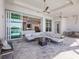 A modern outdoor patio with a gray sectional sofa, a dark marble coffee table, and seamless access to the home's interior at 8335 Sea Glass Ct, Sarasota, FL 34240