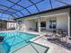 A luxurious screened-in pool and patio area with multiple seating areas and seamless access to the home's interior at 8335 Sea Glass Ct, Sarasota, FL 34240