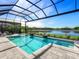 A gorgeous screened pool features lovely lake views and relaxing fountains under an expansive blue sky at 8335 Sea Glass Ct, Sarasota, FL 34240