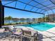 A stunning screened-in pool area with comfortable seating, clear blue water, and scenic views of the surrounding lakefront at 8335 Sea Glass Ct, Sarasota, FL 34240