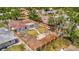 Aerial view of a fenced backyard featuring a patio, fire pit, mature trees, and a lush lawn at 8419 Sylvan Woods Dr, Sarasota, FL 34243