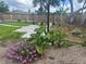 Landscaped backyard featuring a brick-paved walkway, lush greenery, and a newly installed privacy fence at 8419 Sylvan Woods Dr, Sarasota, FL 34243