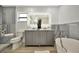 Contemporary bathroom with a double vanity, sleek lighting, soaking tub, and modern fixtures at 8419 Sylvan Woods Dr, Sarasota, FL 34243