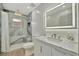 The renovated bathroom features a marble-look tile shower, modern fixtures, and bright lighting at 8419 Sylvan Woods Dr, Sarasota, FL 34243