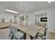 Elegant dining room featuring a large wooden table, stylish seating, and a modern chandelier at 8419 Sylvan Woods Dr, Sarasota, FL 34243