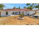 Charming ranch-style home with a well-manicured lawn, lovely seating, and a two car garage at 8419 Sylvan Woods Dr, Sarasota, FL 34243
