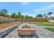 Brick fire pit area with a paved patio and seating, perfect for outdoor entertaining in the backyard at 8419 Sylvan Woods Dr, Sarasota, FL 34243