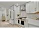 Modern kitchen features stainless appliances, white cabinets and counters, and stylish backsplash at 8419 Sylvan Woods Dr, Sarasota, FL 34243