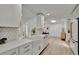 Stylish kitchen showcasing bright white cabinetry, farm sink, quartz counters and stainless appliances at 8419 Sylvan Woods Dr, Sarasota, FL 34243