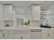 Modern kitchen featuring a farmhouse sink, quartz countertops, and white cabinetry at 8419 Sylvan Woods Dr, Sarasota, FL 34243
