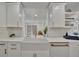 Modern kitchen featuring a farmhouse sink, quartz countertops, and white cabinetry at 8419 Sylvan Woods Dr, Sarasota, FL 34243
