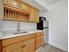 Light wood kitchenette featuring stainless fridge, microwave, countertop, sink, and wood flooring at 8419 Sylvan Woods Dr, Sarasota, FL 34243