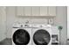 Laundry room includes a sink, storage cabinets, and two modern Samsung washing machines at 8419 Sylvan Woods Dr, Sarasota, FL 34243