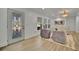 Inviting living room featuring a decorative glass door, modern furniture, hardwood floors, and ample natural light at 8419 Sylvan Woods Dr, Sarasota, FL 34243