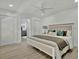 Main bedroom boasts wood-look floors, ceiling fan, and access to ensuite bath at 8419 Sylvan Woods Dr, Sarasota, FL 34243