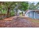 Large backyard with mature trees and grass provides space for recreation at 8470 Magnolia Dr, Seminole, FL 33777